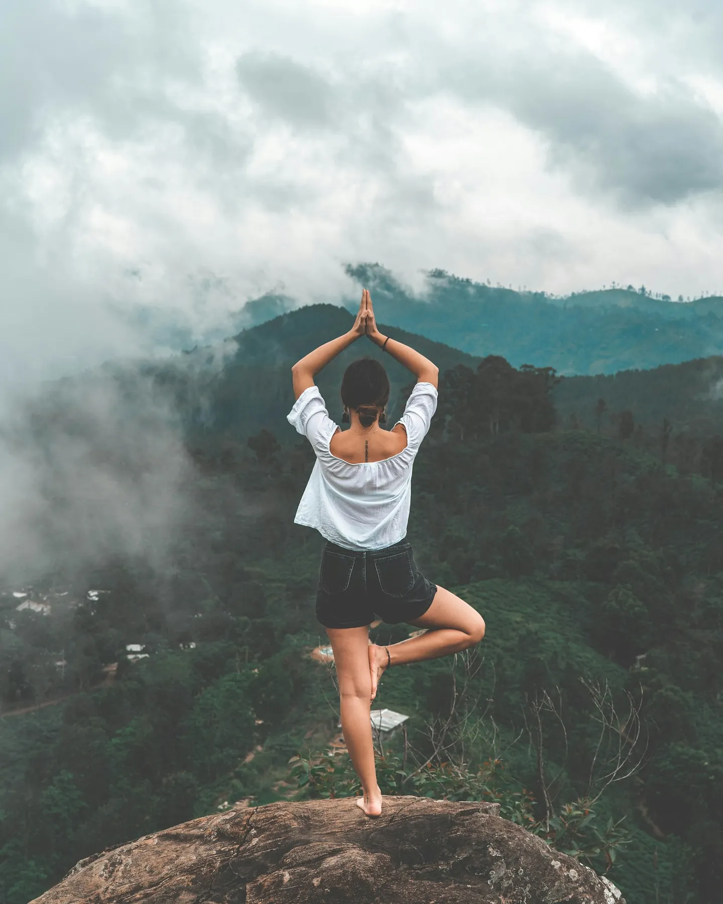 Persona haciendo yoga frente a un bosque